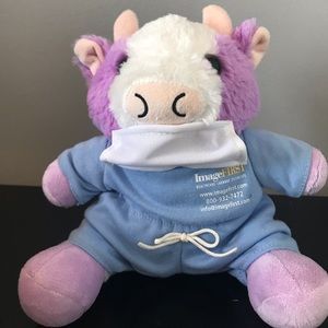 Cow plushie with removable mask! Wearing scrubs saying “Image First” from work.